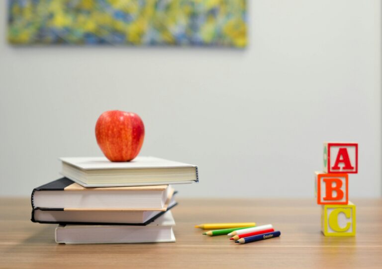 red apple on pile of four books