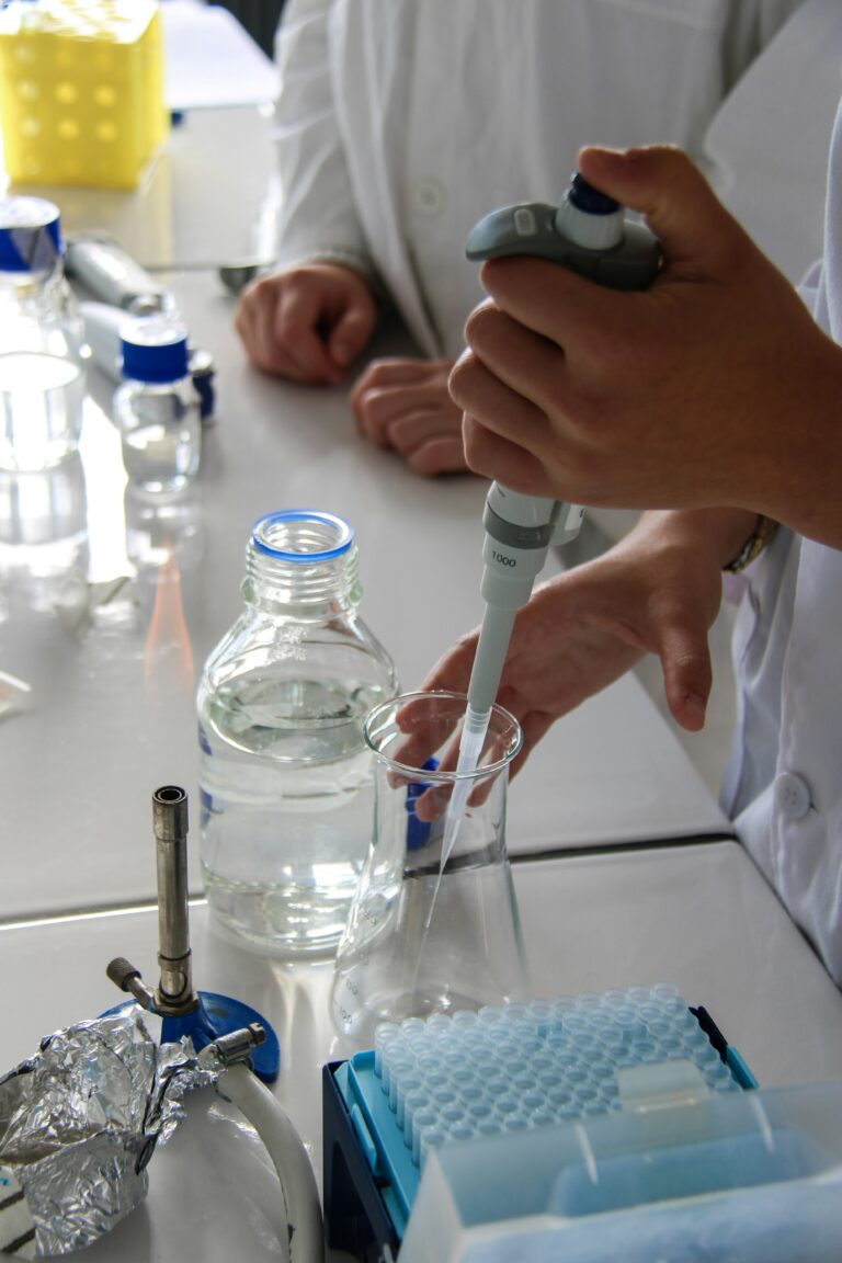 scientist uses pipette to extra liquid in a lab